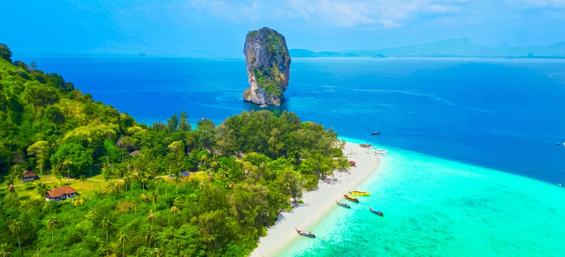 Luftaufnahme von Poda Island bei Krabi in Thailand mit weißem Sandstrand, türkisblauem Wasser und tropischer Vegetation.