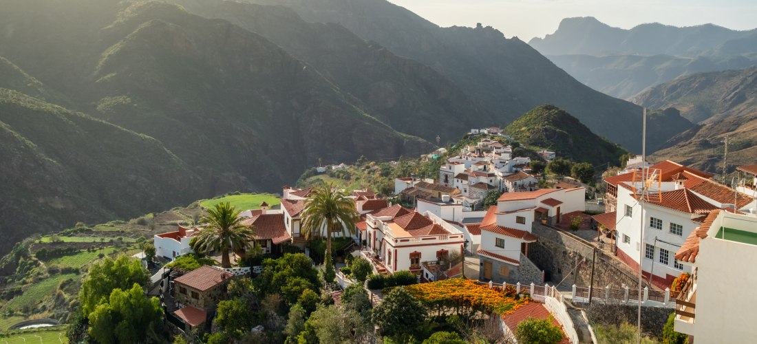 Traditionelles Dorf Tejeda auf Gran Canaria mit weißen Häusern und roten Dächern, umgeben von grünen Tälern und hohen Bergen.