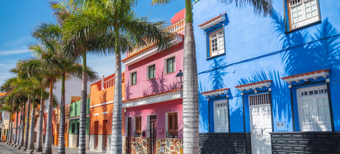 Bunte Häuserfassaden und Palmenallee in Puerto de la Cruz auf Teneriffa