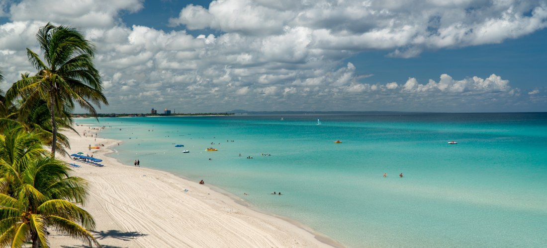Varadero Strand auf Kuba – Karibisches Paradies mit türkisblauem Meer und Palmen Traumhafter Strand von Varadero auf Kuba mit weißen Sandstränden, Palmen, türkisblauem Meer und badenden Urlaubern unter leicht bewölktem Himmel – eines der beliebtesten Reiseziele der Karibik.