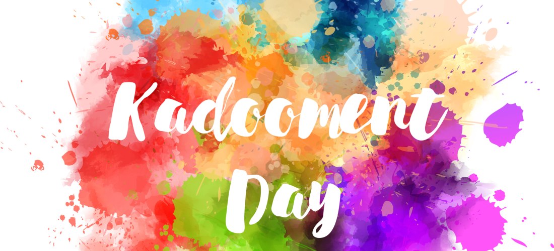 Bunte Farbexplosion in Aquarell-Optik auf weißem Hintergrund. In der Mitte steht in verspielter weißer Schrift: 'Kadooment Day'. Die Farben verlaufen ineinander in Rot, Grün, Blau, Lila, Gelb und Orange – wie bei einem farbenfrohen Karneval.