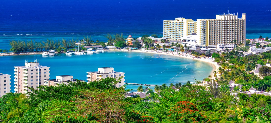 Panoramablick auf Ocho Rios, Jamaika mit Strand, türkisblauem Meer und Hotelanlagen.