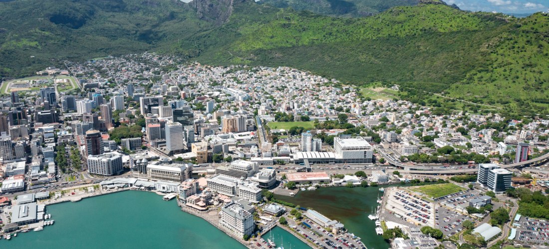Luftaufnahme von Port Louis, der Hauptstadt von Mauritius, mit Hafen und Bergen im Hintergrund