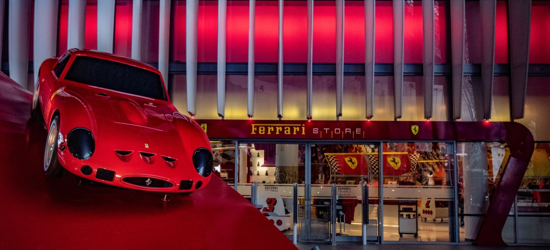 Eingang zum Ferrari Store in Ferrari World Abu Dhabi mit rotem Ferrari-Modellauto als Dekoration