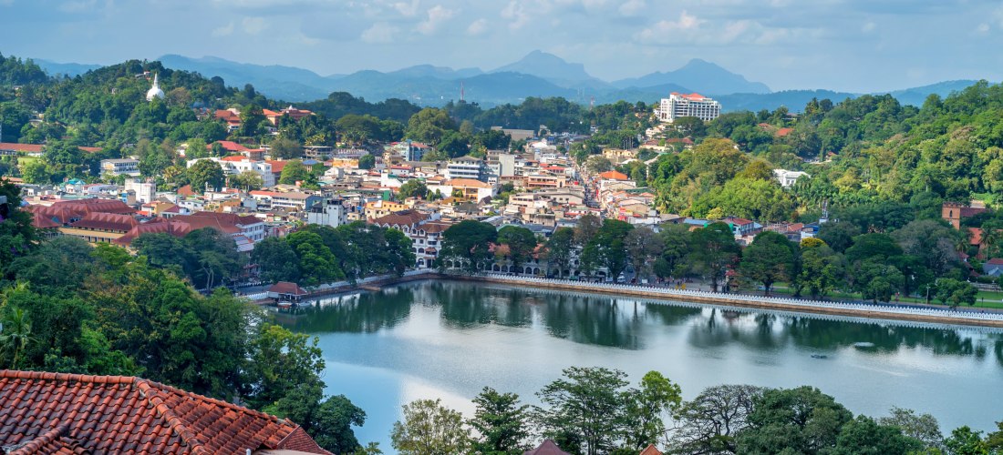Panoramablick auf Kandy in Sri Lanka mit dem Kandy-See, roten Dächern und grünen Hügeln im Hintergrund