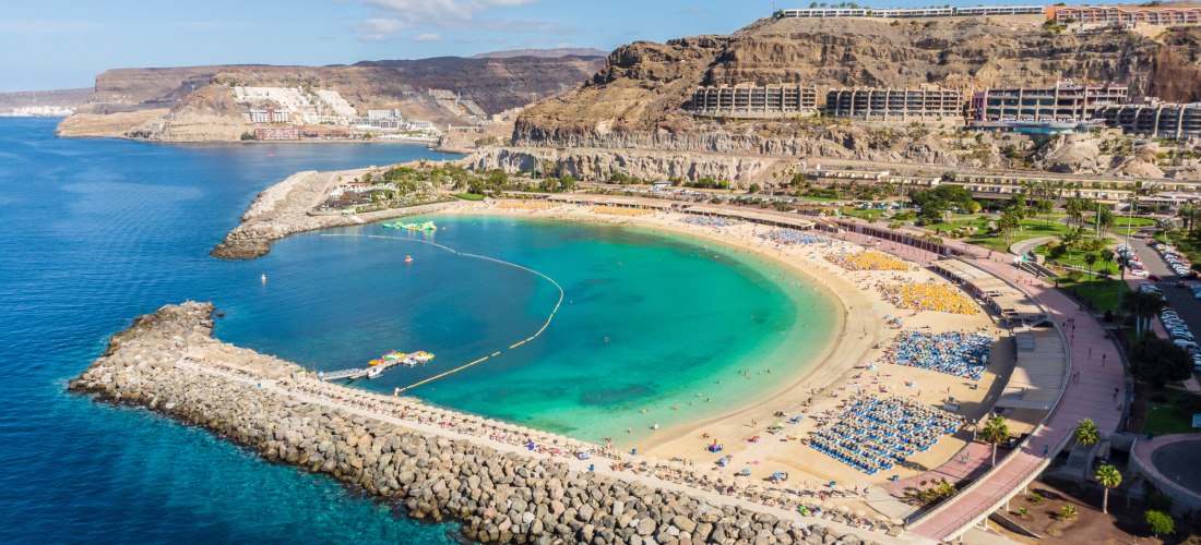 Aussicht von oben, auf eine Bucht, Strand, türkisblaues Wasser, im Hintergrund Berge