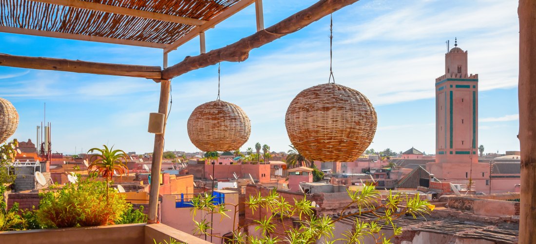 Stimmungsvoller Ausblick von einer Dachterrasse auf die Dächer und Minarette der Medina in Marrakesch, Marokko – traditionelles orientalisches Ambiente.