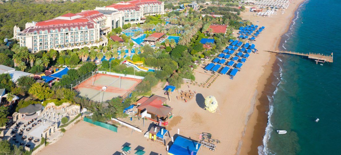 Strand von Side an der türkischen Riviera mit großen Hotels, Sonnenschirmen und Wassersportmöglichkeiten
