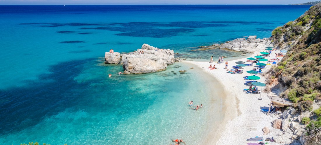 Touristen am Strand sonnen sich und baden