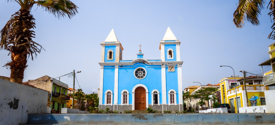 Igreja Nossa Senhora da Luz in São Domingos, Kapverden – strahlend blaue Kirche mit weißen Türmen und Palmen im Vordergrund