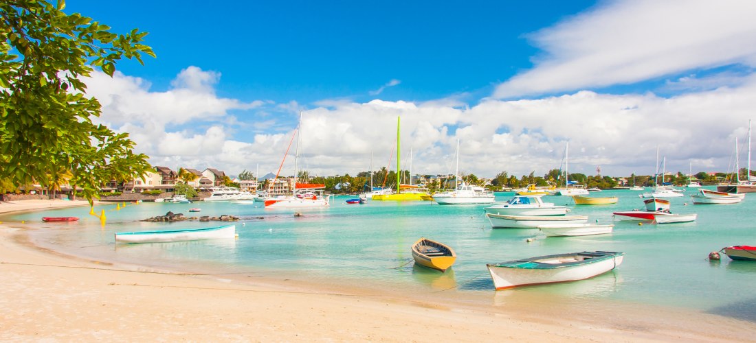 Boote im türkisfarbenen Wasser am Strand von Grand Baie, Mauritius