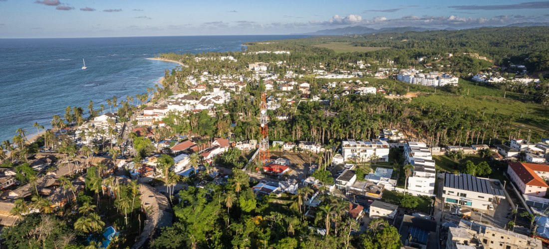 Luftaufnahme von Las Terrenas in der Dominikanischen Republik mit Küstenlinie, Häusern, Hotels und üppiger Vegetation