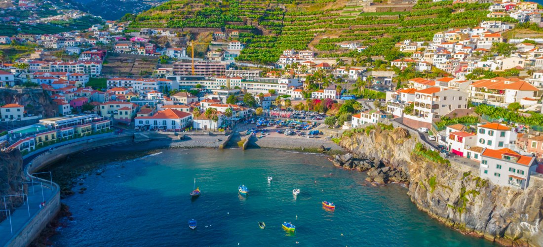 Câmara de Lobos Madeira – Fischerdorf mit Hafen und Weinbergen Luftaufnahme von Câmara de Lobos auf Madeira mit Hafen, Booten und terrassenförmigen Weinbergen an der Küste