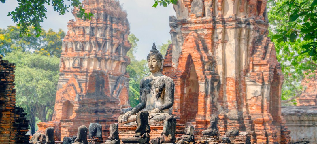 Wat Mahathat in Ayutthaya – Buddhastatuen und antike Ruinen in der historischen Altstadt von Thailand Sitzende Buddha-Statue in den roten Ziegelruinen des Wat Mahathat Tempels in Ayutthaya, Thailand