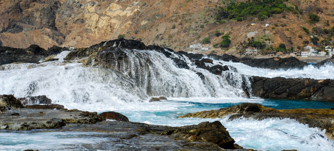 Natürliche Meeresbecken , Kapverden, mit Wellen, die über schwarze Lavafelsen brechen