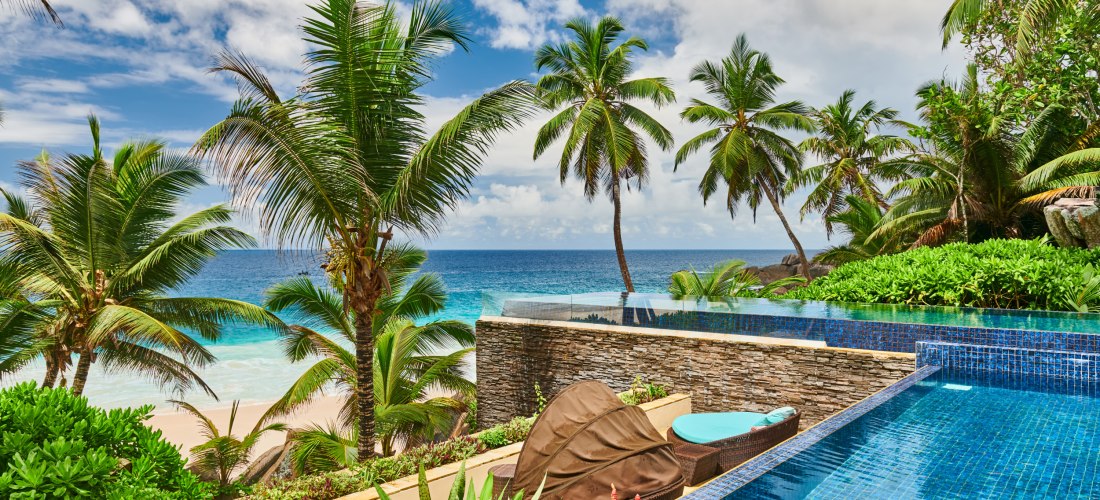 Anse Intendance Seychellen 2025/2026 – Blick von einer luxuriösen Villa mit Pool auf Palmen, weißen Strand und den Indischen Ozean