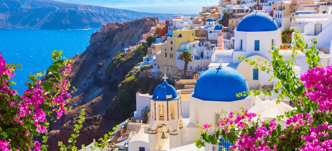 weiße und blaue Gebäude von Santorini auf dem Berg, das Meer im Hintergrund