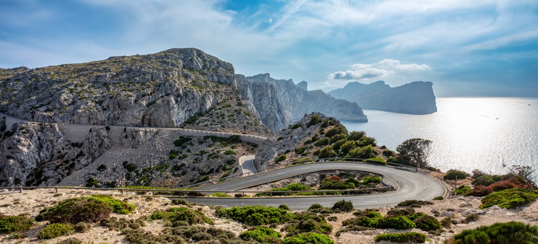 Kurvenreiche Straße entlang der Felsküste von Formentor mit Blick auf das Mittelmeer bei Sonnenlicht