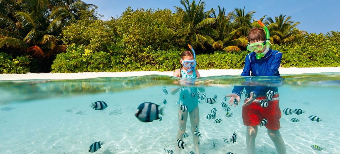 Kinder beobachten Fische beim Schnorcheln