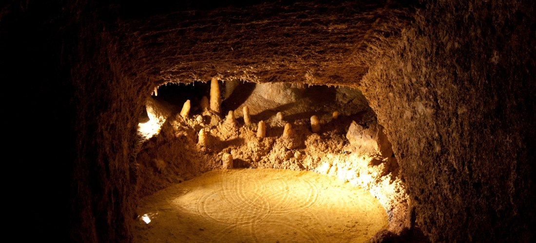 Tropfsteinhöhle auf Barbados mit Stalagmiten und beleuchtetem unterirdischem Wasserbecken.