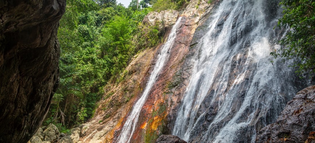 Na Muang 1 Wasserfall auf Koh Samui: 18 Meter hoher Wasserfall mit Naturpool, umgeben von dichtem Regenwald und Felsen.