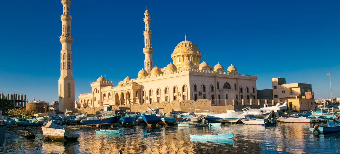 Ägypten - Hurghada Das Bild zeigt die imposante El Mina-Moschee in Hurghada, Ägypten. Die Moschee hat eine große zentrale Kuppel und mehrere kleinere Kuppeln, flankiert von zwei schlanken Minaretten. Sie ist in hellen Tönen gehalten und reich mit Ornamenten verziert. Im Vor