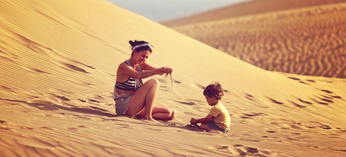Spiel und Spaß in den Sanddünen Mutter und Kind spielen im feinen Sand der Dünen von Maspalomas auf Gran Canaria – ein unvergessliches Erlebnis für Familien und Naturliebhaber.