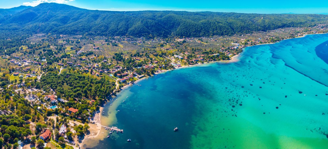 Panoramaaufnahme der Halbinsel Chalkidiki in Griechenland mit endlosen Stränden, türkisblauem Meer und grünen Hügeln. Beliebtes Urlaubsziel für Natur und Badeferien.