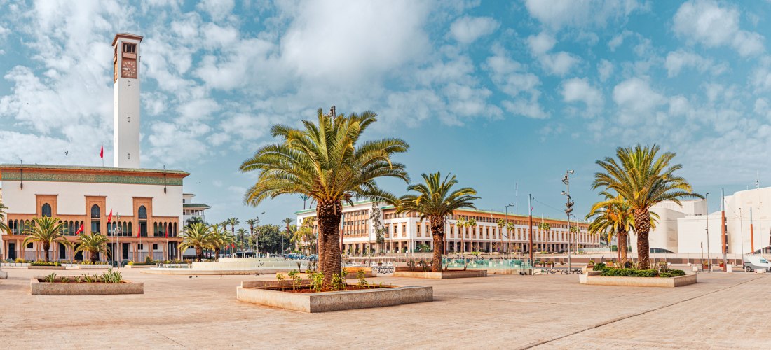 Mohammed-V.-Platz in Casablanca, Marokko, mit Uhrturm, Palmen und historischen Gebäuden – beliebter Treffpunkt und Sehenswürdigkeit im Stadtzentrum.