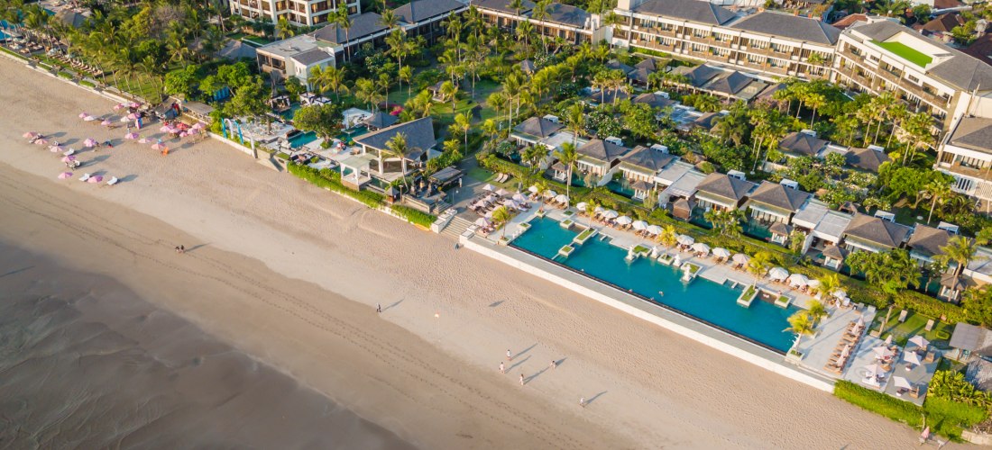 Luftaufnahme des Seminyak Beach auf Bali mit luxuriösen Resorts, Poolanlagen und feinem Sandstrand