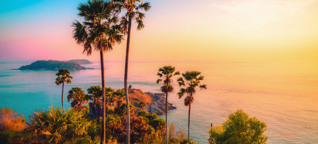 Sonnenuntergang am Laem Promthep Cape Phuket mit Palmen und Blick auf das türkisfarbene Meer
