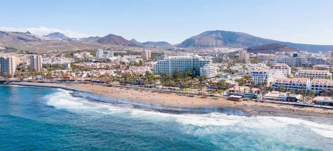 Luftaufnahme von Playa de las Américas auf Teneriffa mit Strand, Hotels und Bergen im Hintergrund