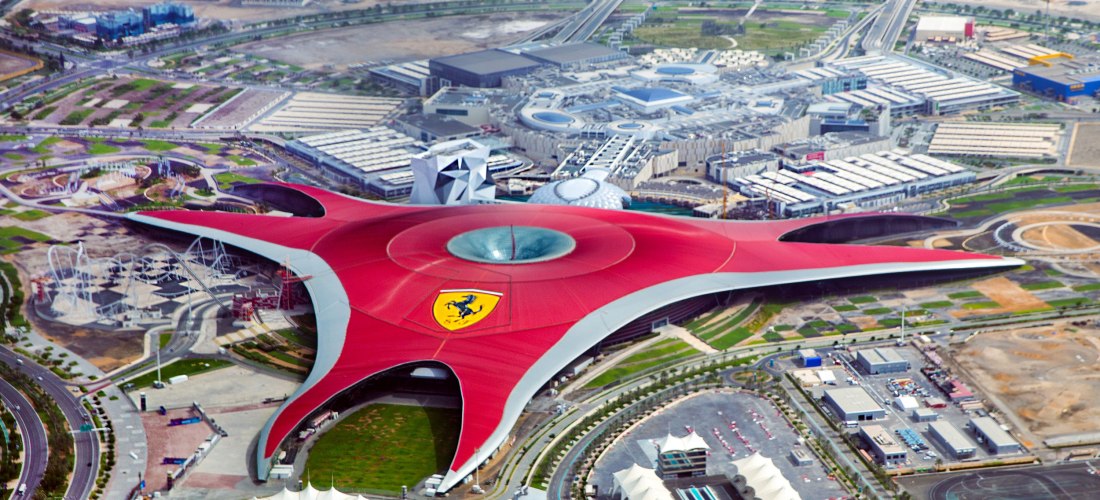 Luftaufnahme von Ferrari World Abu Dhabi mit dem ikonischen roten Dach in Form eines dreizackigen Sterns und dem Ferrari-Logo