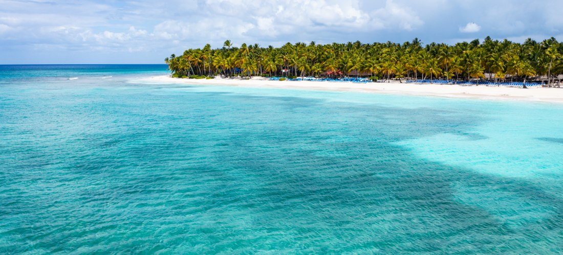 Panorama der Isla Saona mit türkisfarbenem Wasser, Palmenstrand und blauem Himmel in der Dominikanischen Republik