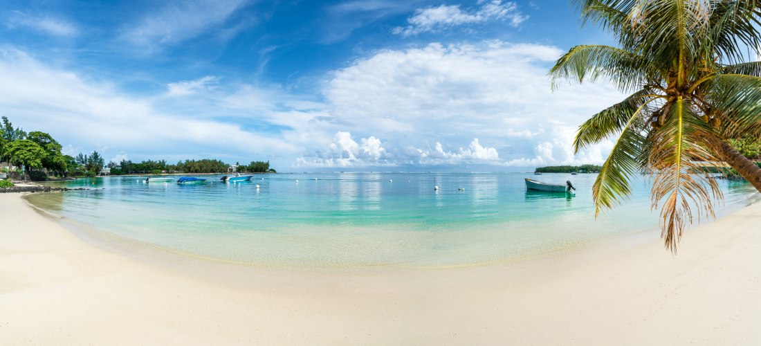 in ruhiger, paradiesischer Strand mit sanften Wellen, schattenspendenden Palmen und glasklarem Wasser – perfekt zum Entspannen und Genießen!