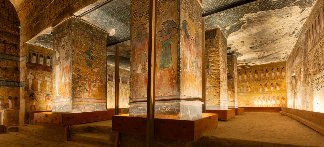 Ägypten - Tal der Könige Das Bild zeigt den reich bemalten Innenraum eines altägyptischen Königsgrabes im Tal der Könige. Mehrere große Säulen sind mit farbenfrohen Wandmalereien und Hieroglyphen versehen, die Götter, Pharaonen und rituelle Szenen darstellen. Die Decke ist in dun