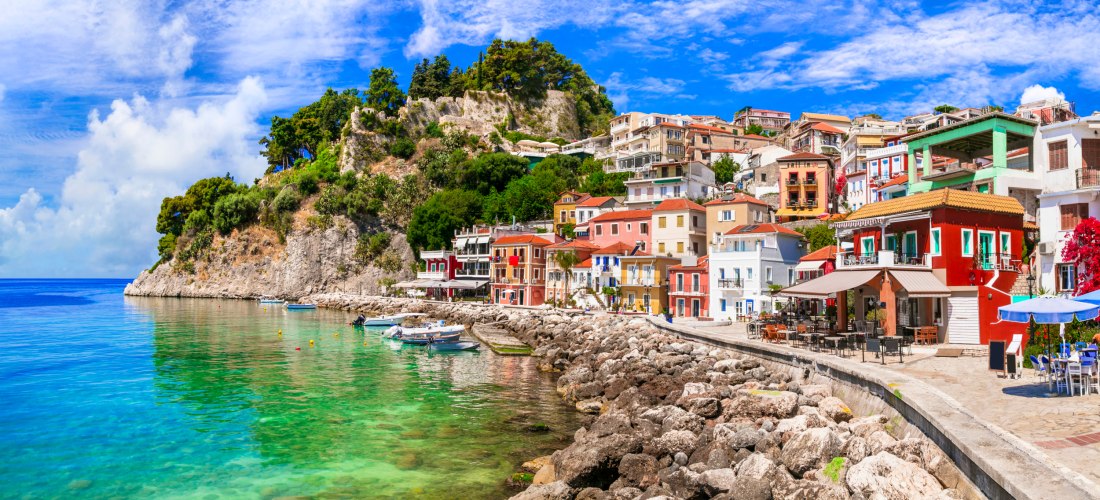 Panorama von Parga auf dem griechischen Festland mit bunten Häusern am Meer, felsiger Küste und kristallklarem Wasser