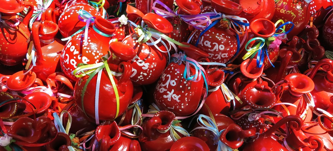  Traditionelles Töpfewerfen zu Ostern auf Korfu: Leuchtend rote Tongefäße mit griechischen Schriftzügen und bunten Bändern sind bereit für das spektakuläre Ritual. Beim „Botides“-Brauchtum werden diese Krüge aus großer Höhe geworfen, um symbolisch das Alt