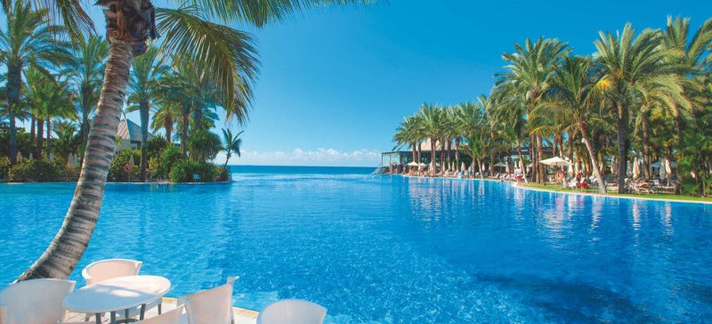 Poolanlage, Liegen, Palmen, Wasser