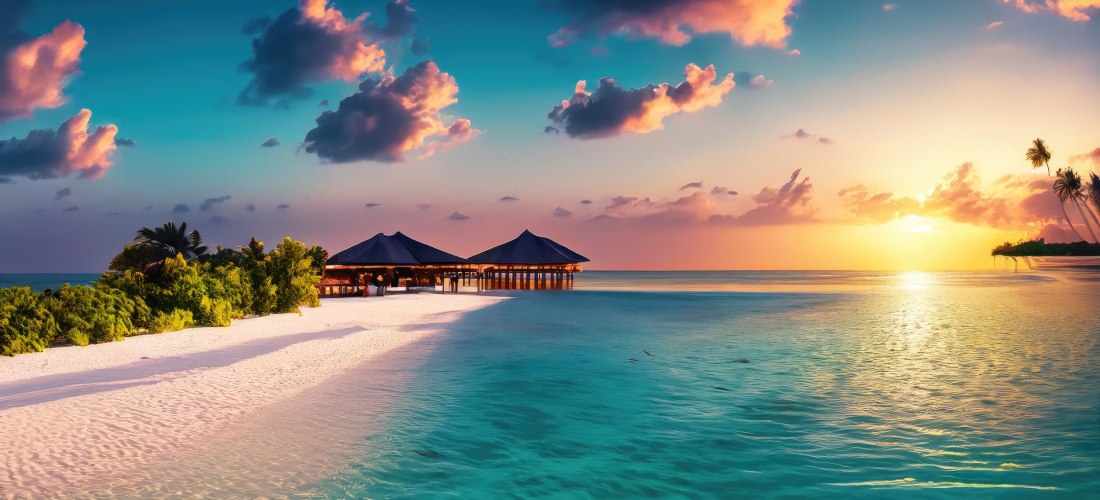 Tropischer Sonnenuntergang an einem weißen Sandstrand mit türkisfarbenem Wasser. Im Hintergrund stehen mehrere strohgedeckte Pavillons auf Stelzen im Meer. Der Himmel ist farbenfroh mit orangefarbenen, rosa und violetten Wolken. Auf der rechten Seite spie
