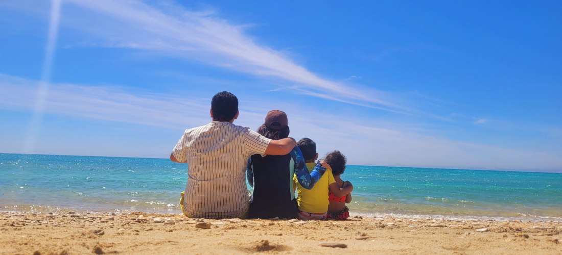 Familie mit Kindern am Strand und Blick aufs Meer