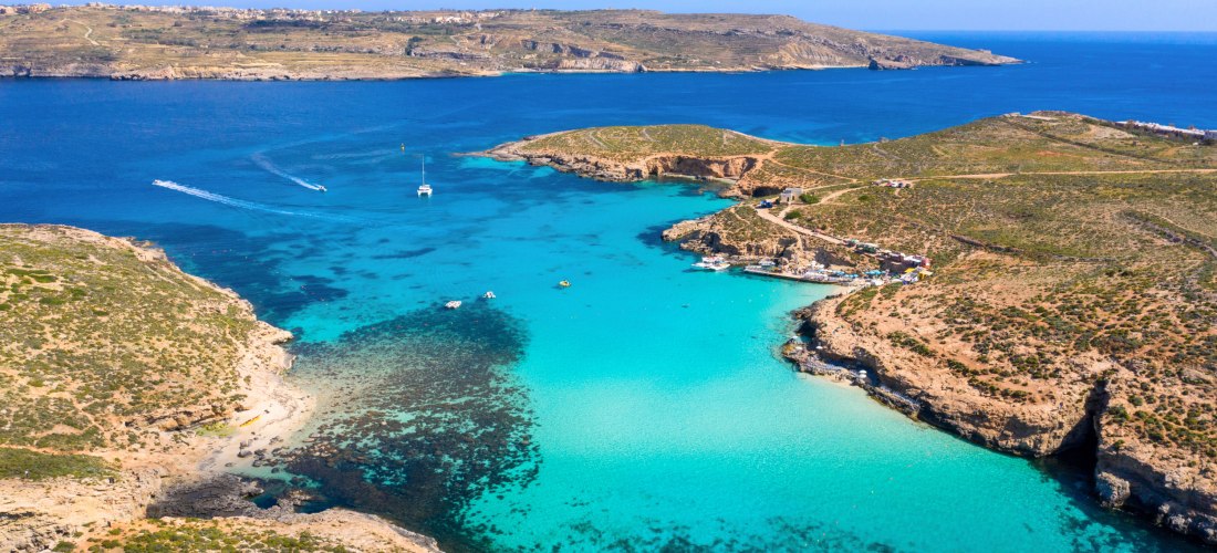 Atemberaubender Blick auf die Blue Lagoon zwischen Malta und Gozo – das leuchtend blaue Wasser und die felsige Küste machen diesen Ort zu einem der beliebtesten Fotospots der Inselgruppe.