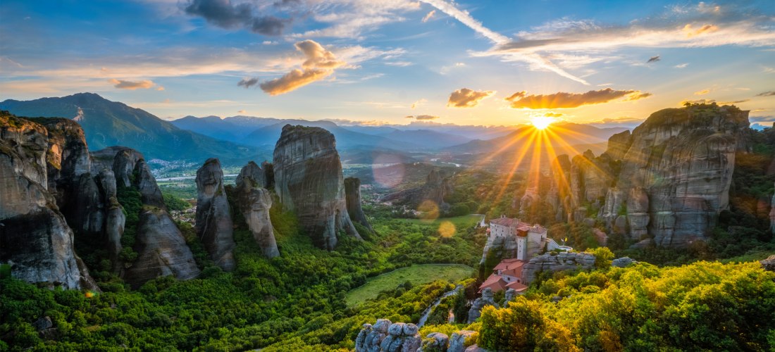 Sonnenuntergang über den Meteora-Klöstern in Griechenland mit spektakulären Felsformationen und grüner Landschaft