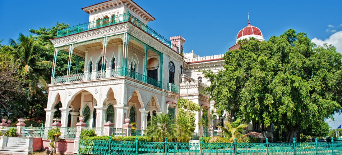 Palacio de Valle in Cienfuegos – architektonisches Juwel Kubas Der prächtige Palacio de Valle in Cienfuegos auf Kuba mit maurisch inspirierten Bögen, filigranen Verzierungen, türkisfarbenen Balkonen und Gartenanlage unter blauem Himmel – ein Wahrzeichen der Stadt.