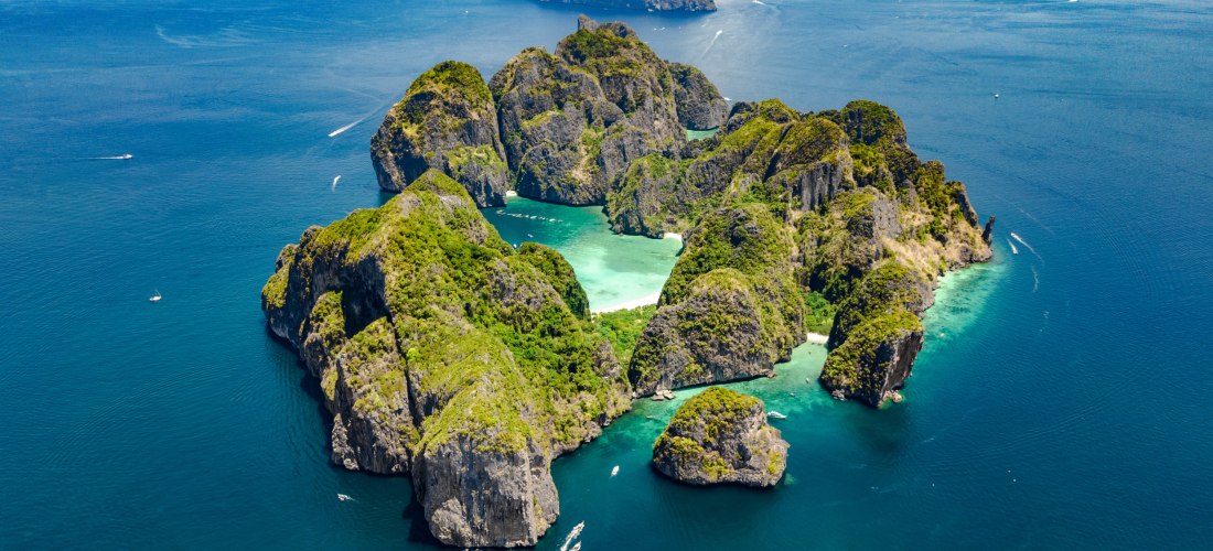 Atemberaubende Luftaufnahme der Phi Phi Islands bei Phuket, Thailand, mit grünen Kalksteinfelsen, weißen Stränden und türkisfarbenem Meer.