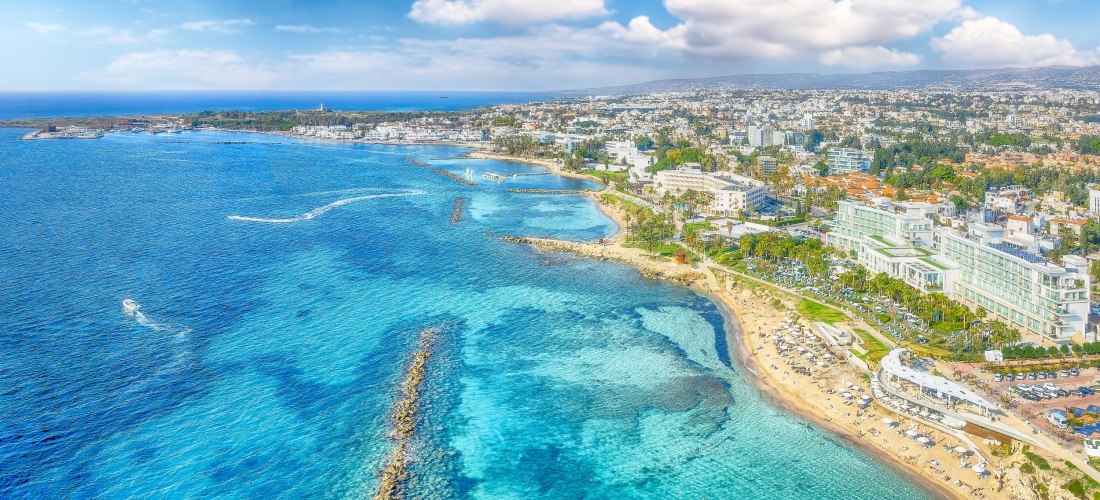 Panoramablick auf Paphos an der Südküste Zyperns mit türkisblauem Meer, Strandabschnitten und Hotels direkt am Wasser.