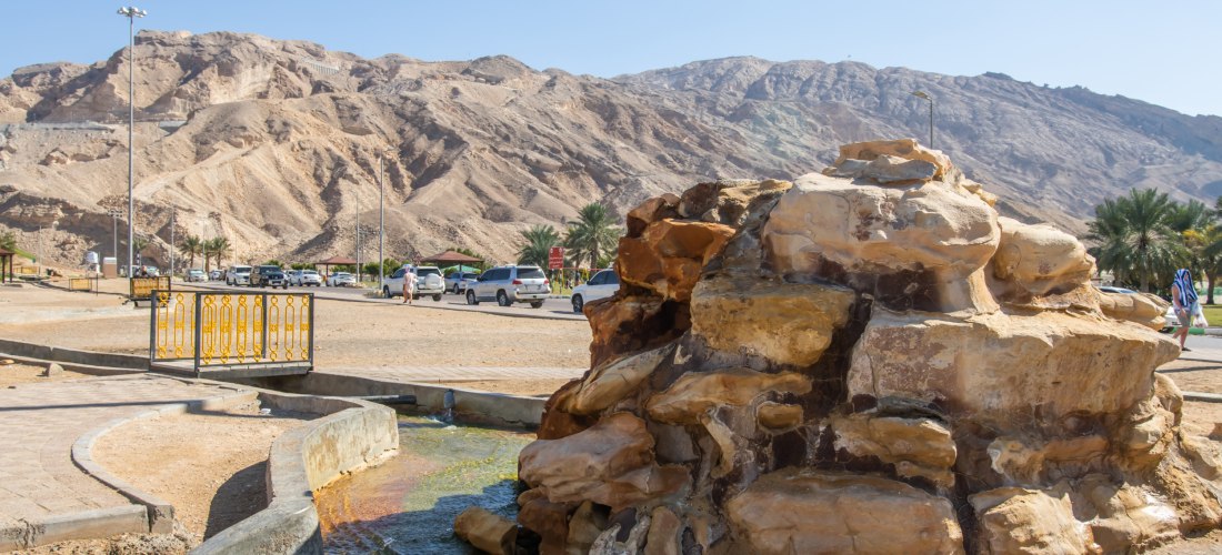 Thermalquelle mit Felsen bei den Hajar-Bergen in Fujairah, Vereinigte Arabische Emirate. Beliebtes Ausflugsziel für Wellness, Entspannung und Naturliebhaber.