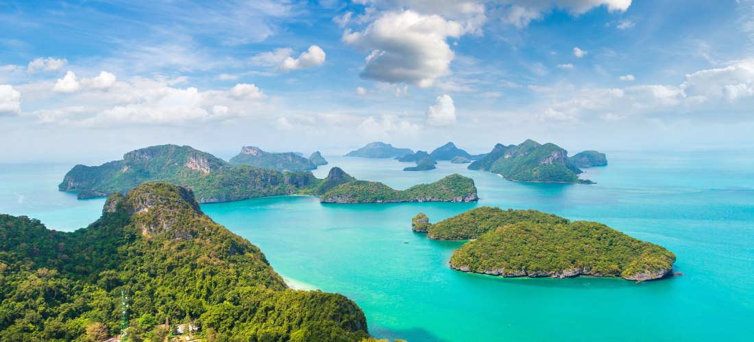 Luftaufnahme der Inseln im Ang Thong National Marine Park bei Koh Samui mit türkisblauem Wasser, bewaldeten Felseninseln und Ausflugsbooten.