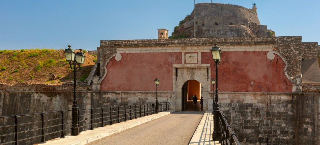 Das Wahrzeichen von Korfu-Stadt: Die alte venezianische Festung erhebt sich über der Stadt und bietet einen majestätischen Eingang mit Brücke und griechischer Flagge. Die Festung zeugt von der wechselvollen Geschichte der Insel und belohnt Besucher mit ei
