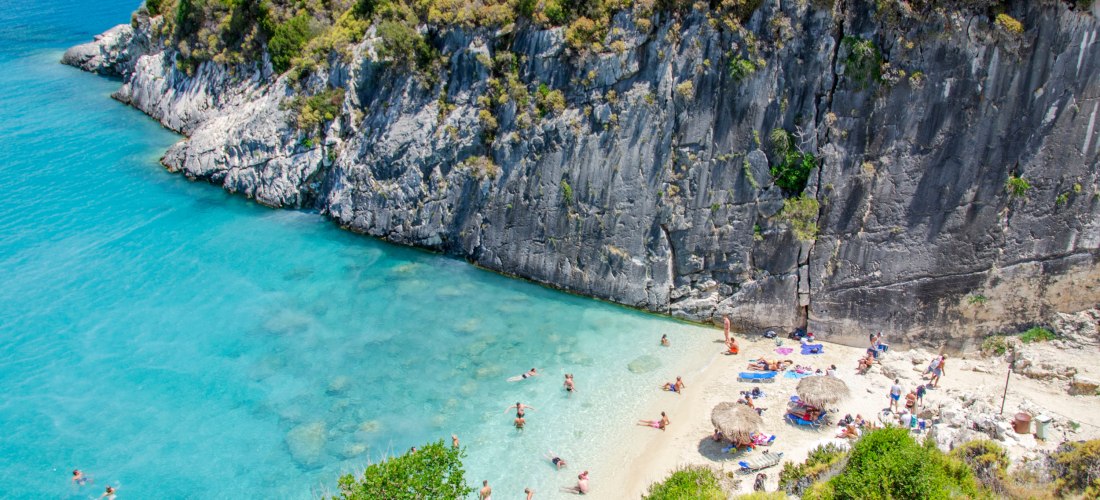 kleiner Strand mit Leuten auf Zakynthos neben einem riesigen Felsen